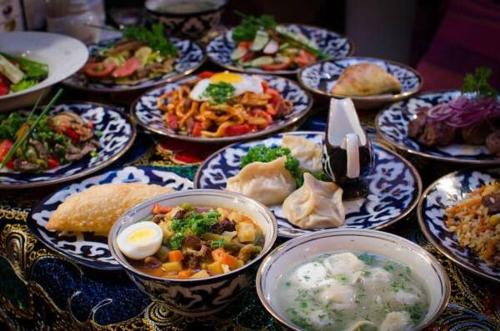 a table with many plates of food on at World Guest House in Samarkand