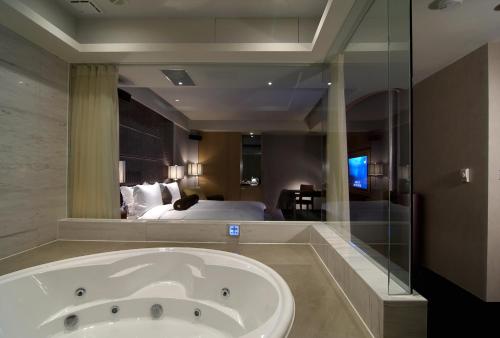 a bathroom with a tub, sink, mirror and bathtub at Tango Motel in Taipei