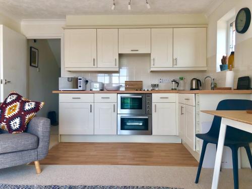 ライにあるWatersideの白いキャビネット、テーブル、椅子付きのキッチン