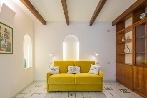 a yellow couch in a room with white walls at Sapore di Sale in Atrani