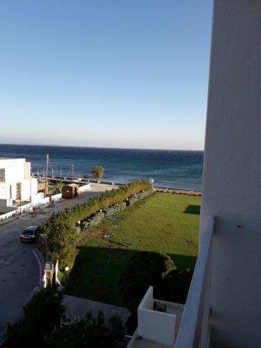 vistas al océano desde el balcón de un edificio en Tinos Beach Hotel, en Kionia