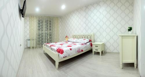 ein weißes Schlafzimmer mit einem Bett und einem Nachttisch in der Unterkunft Standard Plus Apartment in Poltawa