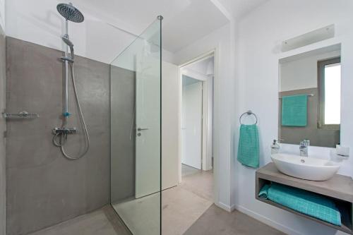 a bathroom with a glass shower and a sink at Luxury Villa Hera with Private Pool in Afantou