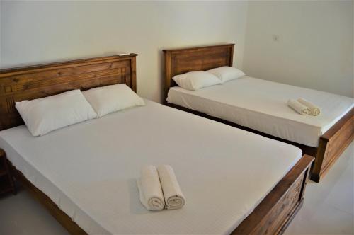 two beds in a room with towels on them at Shim Beach Resort in Arugam Bay