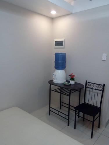 a bedroom with a table with a blender and a chair at Nica's Place Property Management Services at Horizons 101 Condominium in Cebu City