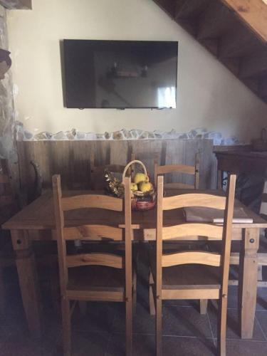 a wooden table with two chairs and a basket of fruit at CAL PINTOR in Ibars de Noguera