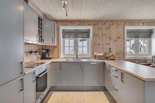 GaustablikkKilen Lodge的厨房配有白色橱柜和水槽