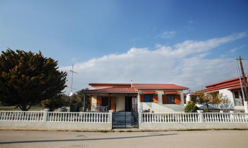 a white fence in front of a house at Halkidiki SeaFront Beach House in Nea Kalikratia