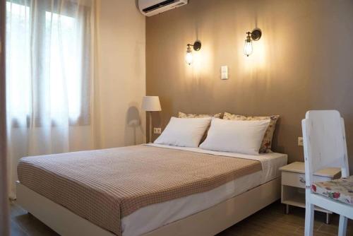 a bedroom with a bed with white pillows and a window at InGreen apartment in Potamia