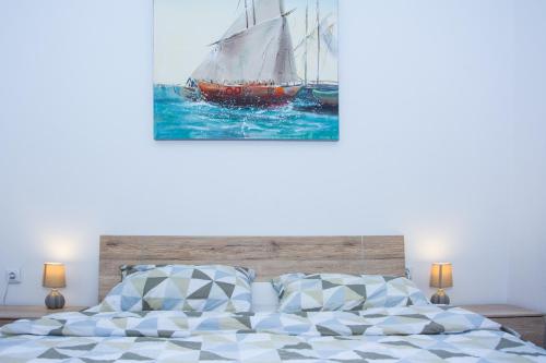ein Bett mit einem Gemälde eines Segelboots in der Unterkunft Patrik Apartment in Senj