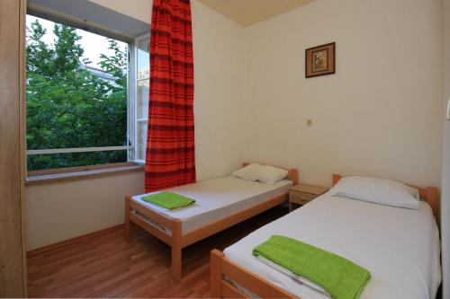 two twin beds in a room with a window at Big and Spacious Apartment in the heart of Omi&scaron; in Omi&scaron;