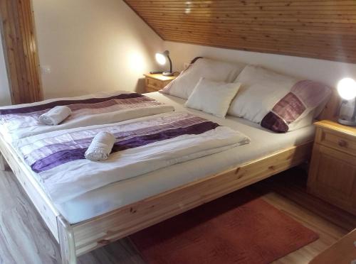 シグリゲットにあるRózsakert Vendégházのベッドルーム1室(大型ベッド1台、木製ヘッドボード付)