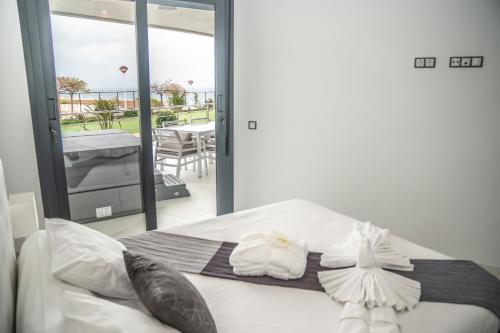 a bedroom with a bed with white pillows and a balcony at Infinity View Paradise Apartment in Arenales del Sol