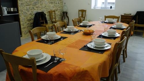 a dining room with a long table with plates and glasses at Chez Mary in Vanosc