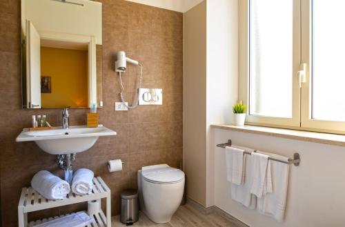 a bathroom with a toilet and a sink and a mirror at Taormina Bedda Rooms in Taormina