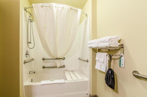 a bathroom with a shower and a tub and a toilet at Cobblestone Hotel & Suites - McCook in McCook