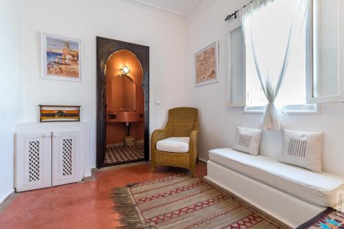 a living room with a chair and a mirror at Dar el Maq - Antlantic view & Sauna in Asilah