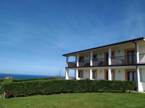 a large white building with bushes in front of it at El Ribero de Langre in Langre