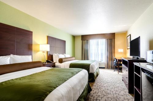 a hotel room with two beds and a television at Cobblestone Hotel & Suites - McCook in McCook