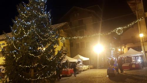 a christmas tree on a street at night with lights at Hotel Gran Baita in Gressoney-Saint-Jean