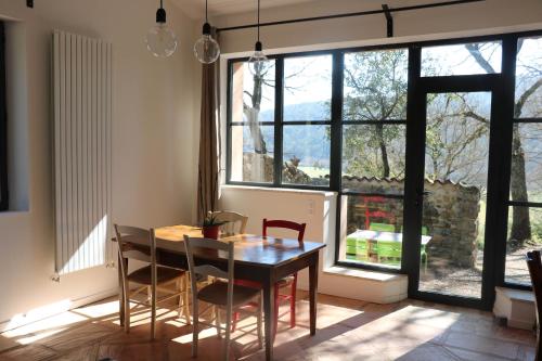 une salle à manger avec une table et des chaises et une fenêtre dans l'établissement Le clos des collines, à Saint-Martin-de-Brômes
