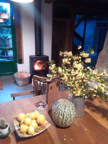 a table with fruit and flowers and a fireplace at La Figal de Xugabolos, Salas in Salas