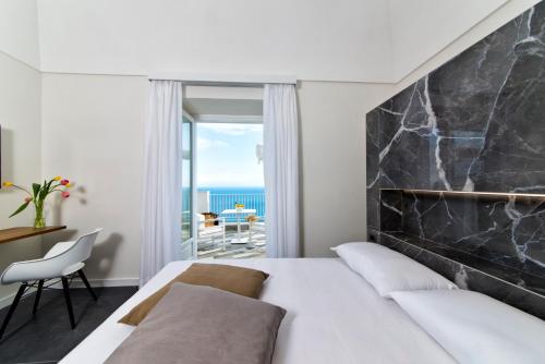 a bedroom with a bed and a view of the ocean at villa orleans in Amalfi
