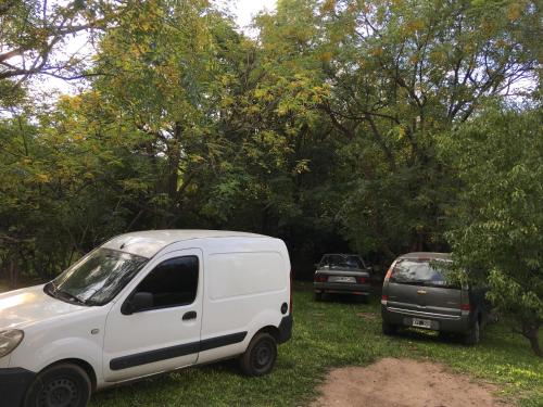 due auto parcheggiate sull'erba accanto agli alberi di Lo de Jenny a San Marcos Sierra