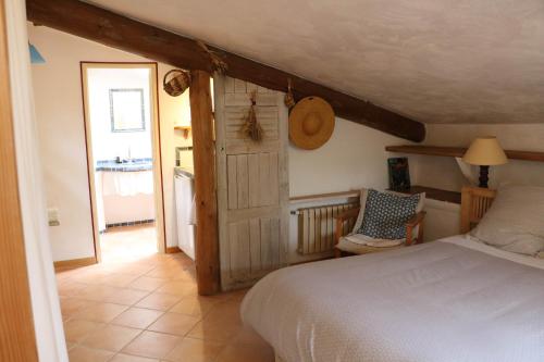 - une chambre avec un lit, une porte et une chaise dans l'établissement Le clos des collines, à Saint-Martin-de-Brômes