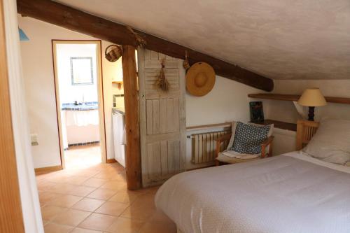 Saint-Martin-de-BrômesにあるLe clos des collinesのベッドルーム1室(ベッド1台、ドア、椅子付)