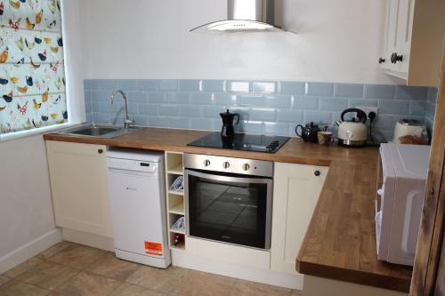 a small kitchen with a sink and a stove at Pickles Cottage in Barnoldswick