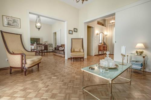 ein großes Wohnzimmer mit einem Tisch und Stühlen in der Unterkunft Bella Venezia Residence in Korfu-Stadt