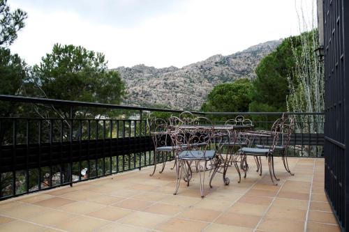 a patio with tables and chairs on a balcony at Piedra Libre Apartamentos in Manzanares el Real
