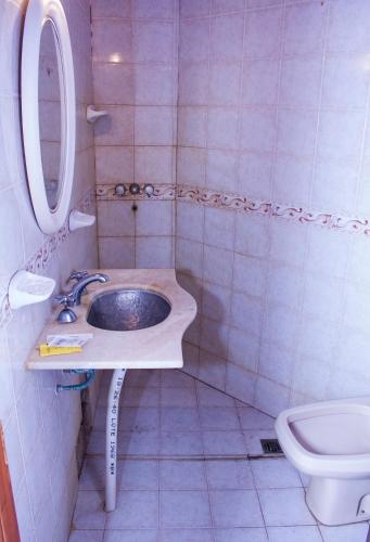 a bathroom with a sink and a toilet at Departamentos 27 in San Clemente del Tuyú