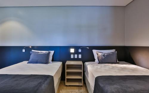 two beds sitting next to each other in a room at Quality Hotel Blumenau in Blumenau