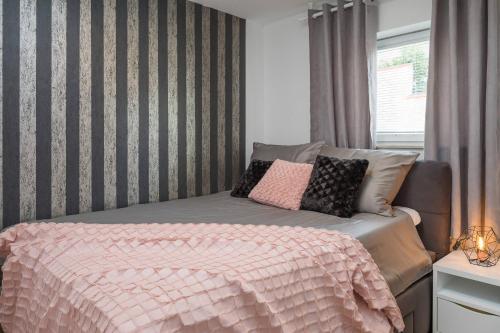 a bedroom with a bed with a pink comforter at Apartments Habek in Vrboska
