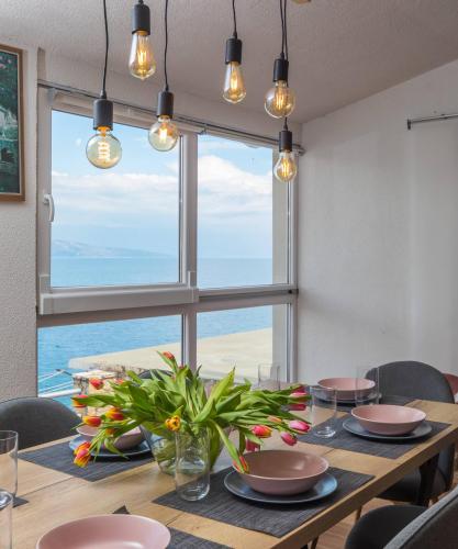 a dining room with a table and a large window at Apartments Habek in Vrboska