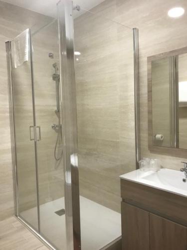 a bathroom with a shower and a sink at Pensión CHE in O Pedrouzo