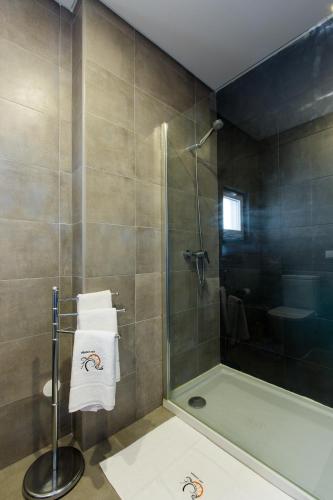 a bathroom with a shower and a toilet and towels at Vitamin Sea, The Terrace Apartment in Baleal
