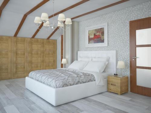 a white bedroom with a large white bed and a chandelier at Vila Lily in Smederevo