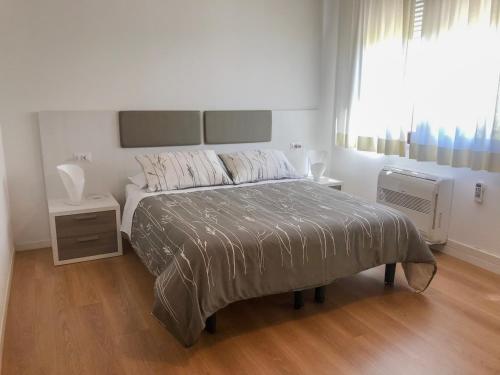 um quarto branco com uma cama grande e uma janela em Four Rooms Guesthouse em Oristano