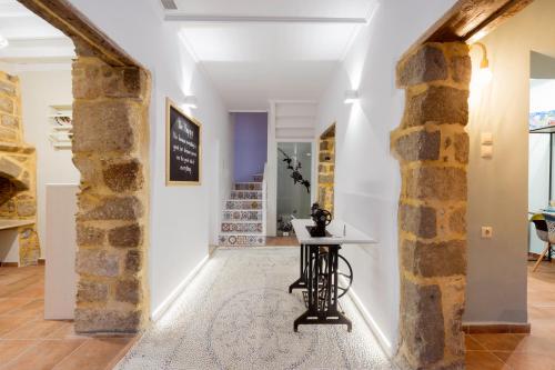 a hallway with a table and a brick wall at A33 Rhodes Old Town House in Rhodes Town