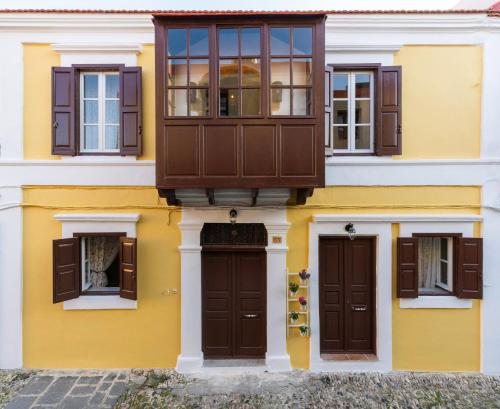 a yellow and white building with brown doors and windows at A33 Rhodes Old Town House in Rhodes Town