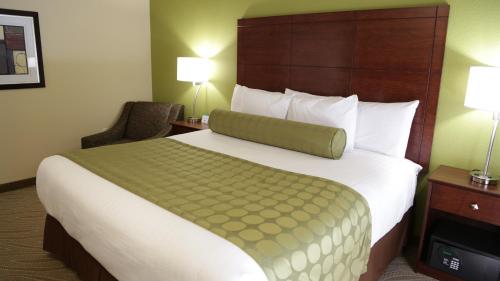 Cette chambre comprend un grand lit et une chaise. dans l'établissement Cobblestone Inn & Suites - Marquette, à Marquette