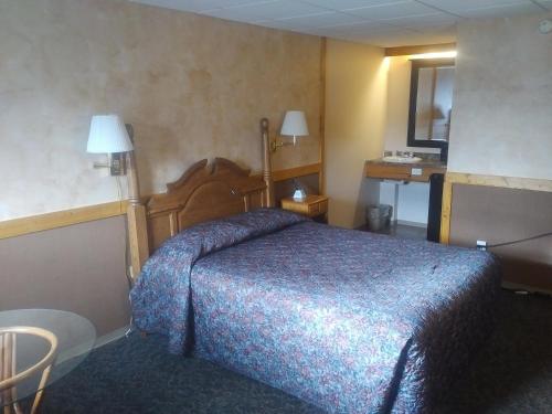 ein Schlafzimmer mit einem Bett in einem Hotelzimmer in der Unterkunft Algoma Motel in Wawa