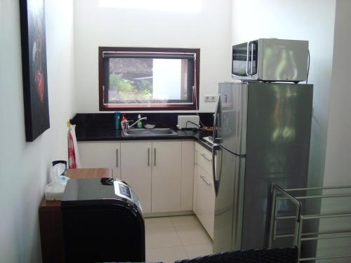 a kitchen with a refrigerator and a sink and a window at Dream Estate Resort in Senggigi 