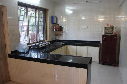 a kitchen with a black counter top and a refrigerator at Ladakh House- 3 BHK Ladakh themed Villa near Matheran in Neral