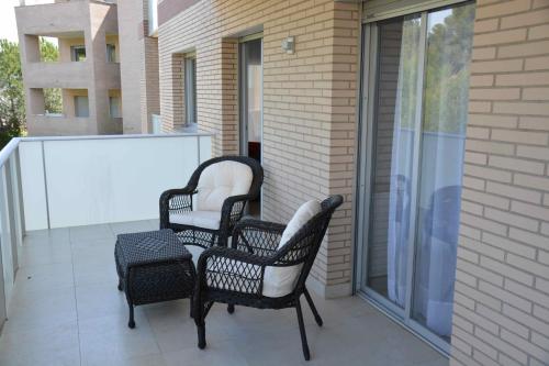 three chairs and a table on a balcony at Saval Spa Aqquaria Family Complex in Salou