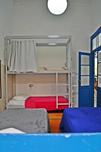 a room with two bunk beds and a blue door at Brasileranza Hostel in Niterói