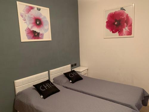 リモーネ・スル・ガルダにあるVilla Castelloの壁に写真2枚が飾られた客室内のベッド2台